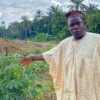 Anthony Adejuwon points at the polluted water.