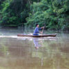 A member of the Indigenous Tikuna nation paddling a dugout canoe on a tributary of the Amazon in Colombia by Rhett A. Butler/Mongabay.
