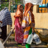 People line up to collect water from a community tap.