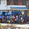 Residents of Port-au-Prince wait outside a store to purchase bottled water.