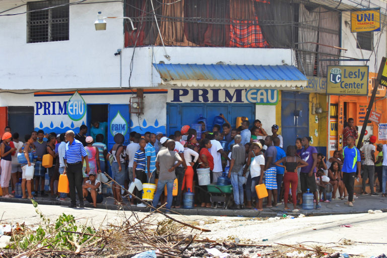 Residents of Port-au-Prince wait outside a store to purchase bottled water.