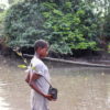 A community member carries mangrove seedlings to be planted. Image by Orji Sunday for Mongabay.