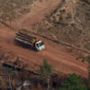 A logging truck through deforested lands.