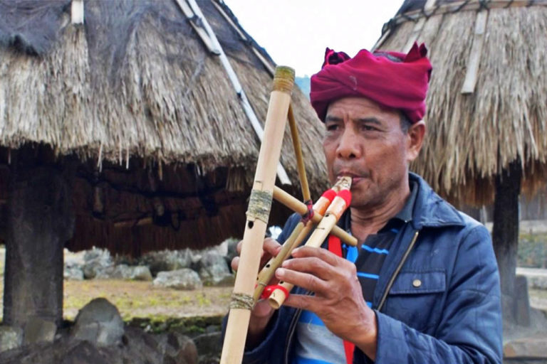 Marselus Selu plays traditional bamboo musical instruments.