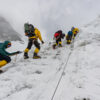 The National Geographic and Rolex Perpetual Planet Everest Expedition team climbs up a steep slope.