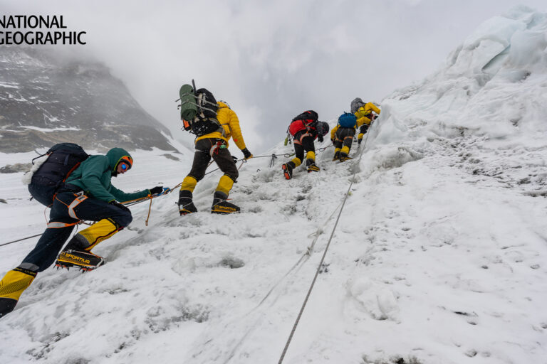 The National Geographic and Rolex Perpetual Planet Everest Expedition team climbs up a steep slope.