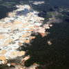 Aerial view of Amazon rainforest landscape scarred by open pit gold mines