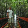 Roque Regis, one of Paraiso’s community leaders, stands on a bridge through the bay's mangroves.
