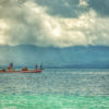 A group of traditional fishermen in small boats catching fish in the waters of Maluku.