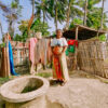 A woman stands next to a well with water that tastes salty due to seawater interference.